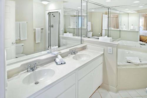 a white bathroom with two sinks and a large mirror at Hilton Vacation Club Greensprings Williamsburg in Williamsburg
