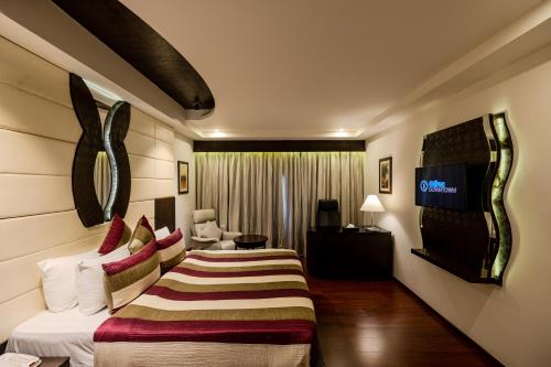 a hotel room with two beds and a television at Olive Downtown in Cochin