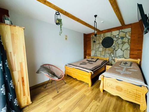 sypialnia z 2 łóżkami i kamienną ścianą w obiekcie Willa Mnich w Bukowinie Tatrzańskiej