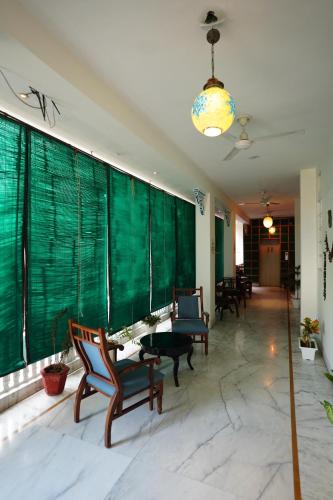 a lobby with chairs and a table and a green wall at Haveli Kalwara - A Heritage Hotel in Jaipur