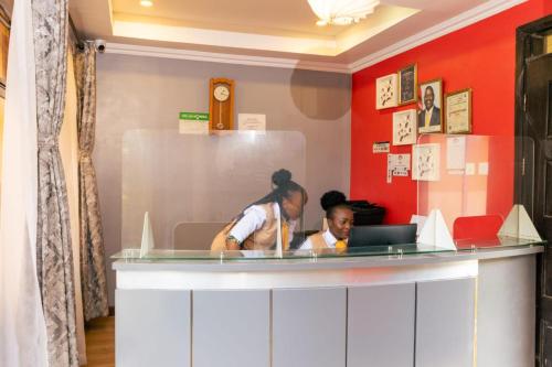 two people sitting at a counter in a restaurant at Eseriani The Hotel in Naivasha