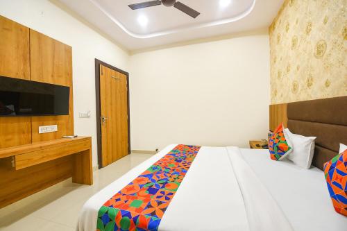 Un dormitorio con una cama y un televisor de pantalla plana. en FabHotel Golden Tree, en Amritsar