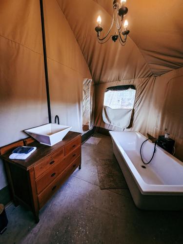 a bathroom with a tub and a sink in a tent at Aloeron at Patatsfontein Stay in Montagu