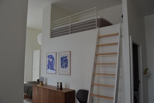 a bedroom with a bunk bed and a ladder at Hotel Lille Nyhavn in Skanderborg