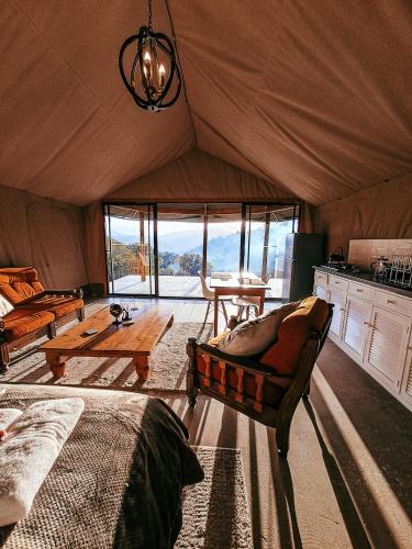 a living room with a couch and a table in a tent at Aloeron at Patatsfontein Stay in Montagu