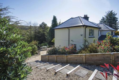 a small white house with a fence in front of it at Taf Fechan - 3 Bedroom House - Pontsticill in Merthyr Tydfil