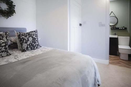 a white bedroom with a bed and a sink at Taf Fechan - 3 Bedroom House - Pontsticill in Merthyr Tydfil