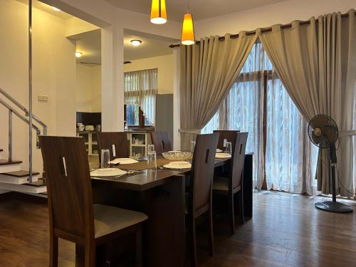 a dining room with a table and chairs and curtains at Occazia Residence in Colombo