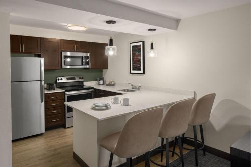 a kitchen with a large white island with bar chairs at Residence Inn Portland Hillsboro in Hillsboro