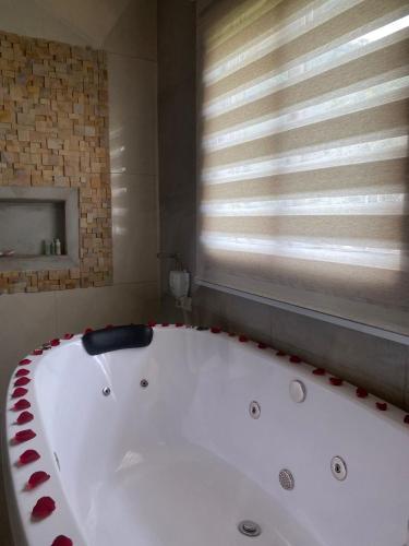 a large white bath tub in a bathroom with a window at Refúgio dos pinhais in Sapucaí-Mirim