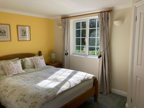 a bedroom with a bed and a window at October House Holiday Cabin in Fordingbridge