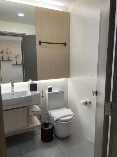 a bathroom with a sink and a toilet and a mirror at Suasana Suites Johor Bahru City Centre in Johor Bahru