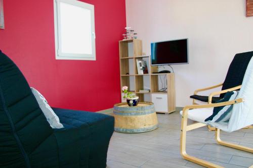 a living room with two chairs and a tv at Gite Entre Terre Et Ciel in Saint-Vincent-de-Pertignas