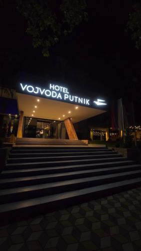 a hotel with a sign on top of a building at Hotel Vojvoda Putnik in Vranje