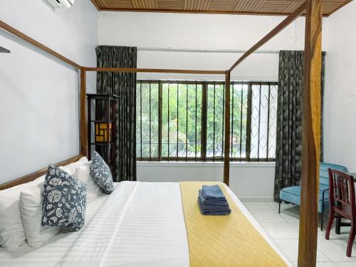 a bedroom with a bed and a large window at Birdcage Boutique in Phnom Penh