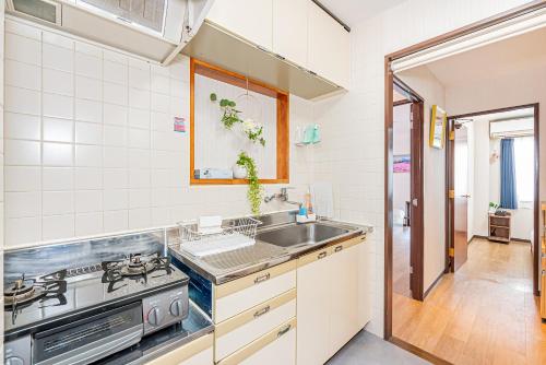 a kitchen with a sink and a stove at Bright Modern Airbnb in Tokyo's Northern District in Tokyo