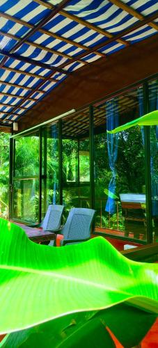 two chairs and a bed in a room with windows at Samyama Retreat in Cola