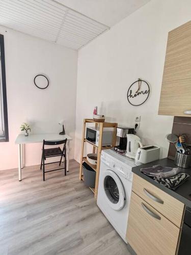 une cuisine avec une machine à laver et une table dans l'établissement Charmant T2 RDC, à Brest