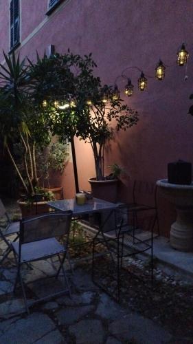 a patio with a table and chairs at night at Appartamento Arte in Imperia