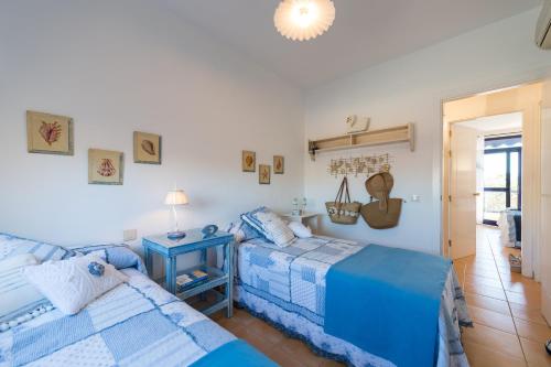 2 Betten in einem Schlafzimmer mit blau und weiß in der Unterkunft Bahía Meloneras Relax in San Bartolomé de Tirajana
