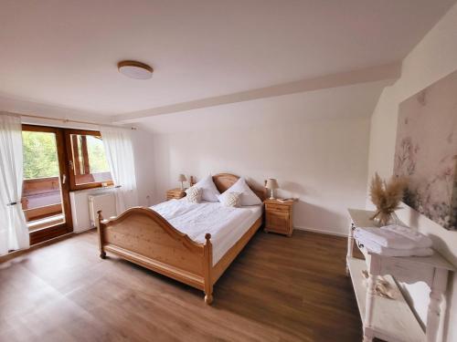 a bedroom with a wooden bed and a window at Ferienwohnung Goldfasan in Lam