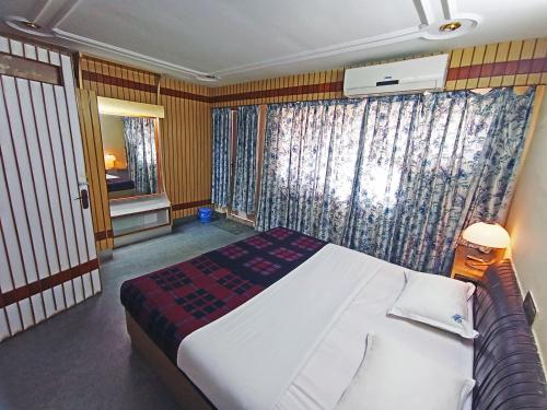 a bedroom with a large bed and a window at Hotel Chetana in Dāvangere