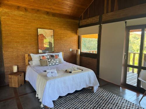 a bedroom with a bed with a white bedspread at Refúgio dos pinhais in Sapucaí-Mirim