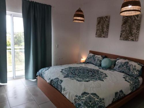una camera da letto con un letto e una grande finestra di Tropical Villa Escape in Sosua a Sosúa