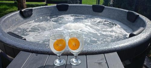 due bicchieri di champagne appoggiati su un tavolo in una vasca idromassaggio di Baliowy Żar nad jeziorem w Międzybrodziu a Miedzybrodzie Żywieckie