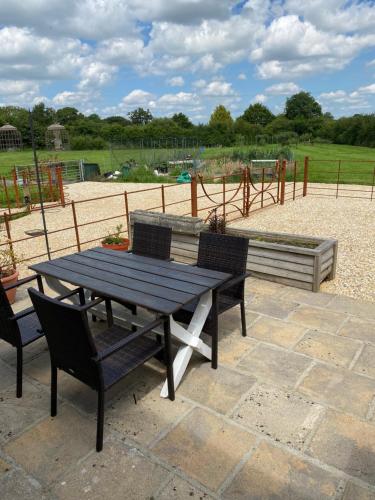 a picnic table and two chairs with a park in the background at Cottage Retreat- Sleeps 4 Garden in Sherborne