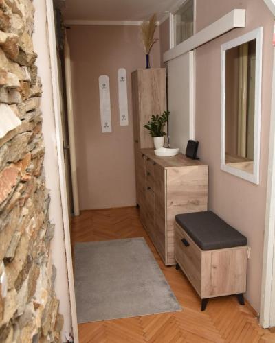 a room with a dresser and a stool and a mirror at Apartman K2 in Valjevo