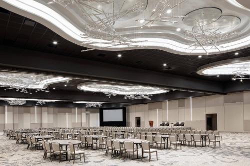 a conference room with tables and chairs and a screen at Odessa Marriott Hotel & Conference Center in Odessa