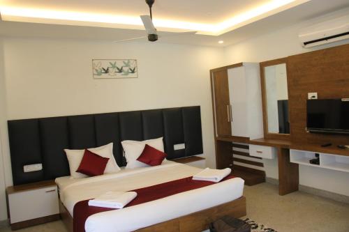 Un dormitorio con una cama grande y un televisor. en Oxy Valley Resorts, en Agali