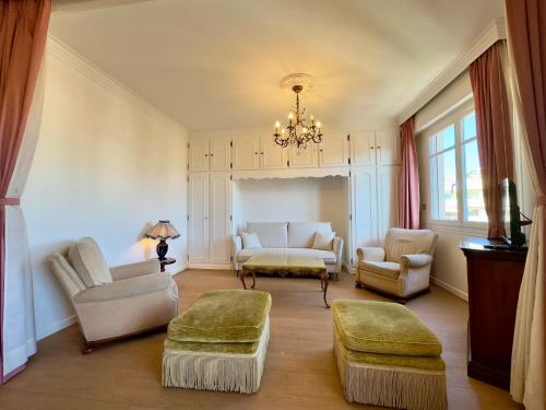 Elle comprend un salon doté d'un mobilier blanc et d'un lustre. dans l'établissement Horizon By SCLS Locations, à Cannes