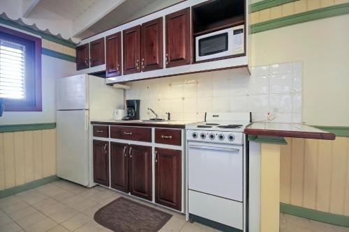 a kitchen with a white stove and a microwave at Mary's Boon Beach Plantation Resort & Spa in Simpson Bay