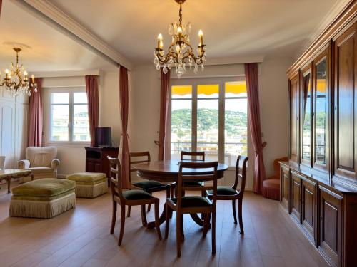 une salle à manger avec une table, des chaises et un lustre dans l'établissement Horizon By SCLS Locations, à Cannes