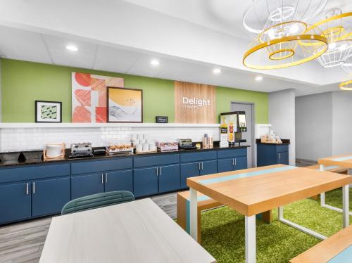 a kitchen with blue cabinets and a wooden table at Spark by Hilton Augusta in Augusta