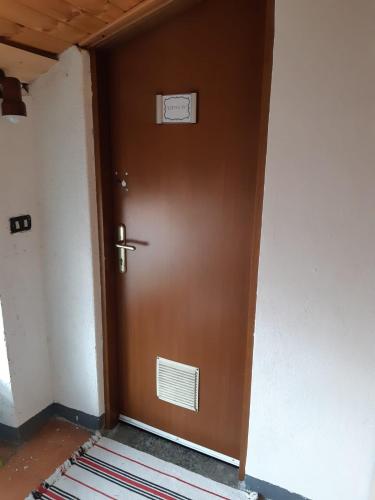 a brown door in a hallway with a sign on it at Little 58 in Luino