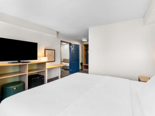 a room with a bed and a flat screen tv at Spark by Hilton Augusta in Augusta