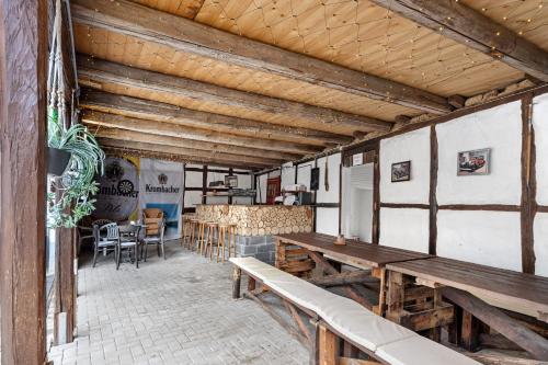 a patio with wooden benches and a table at Gruppenhaus Osterhagen in Bad Lauterberg