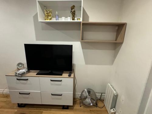 - une télévision sur une commode dans l'établissement Appartement Paris 13, à Paris