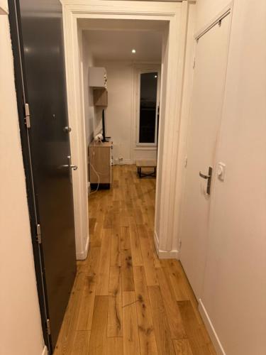 - un couloir avec deux portes et du parquet dans l'établissement Appartement Paris 13, à Paris