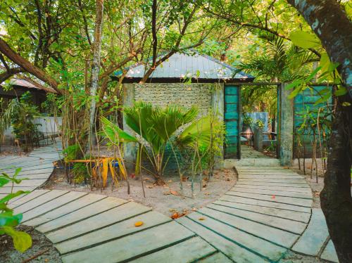 a walkway in front of a building with trees at Mi Lugar Maldives in Nolhivaranfaru