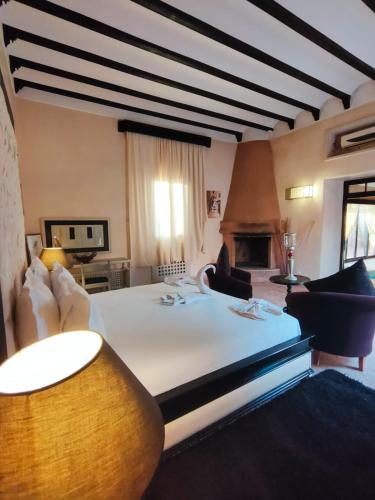 a bedroom with a bed and a couch and a fireplace at Riad shéhérazade Marrakech in Marrakesh