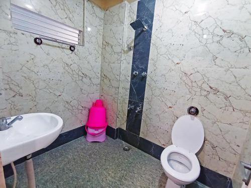 a bathroom with a toilet and a sink at Hotel Chetana in Dāvangere