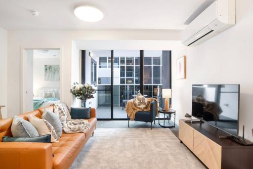 a living room with a couch and a television at The Waymouth Executive I Workspace I Free Parking in Adelaide