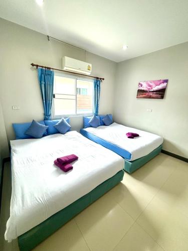 two beds in a room with blue pillows at Dream pool villa 2 in Ban Nong Chap Tao