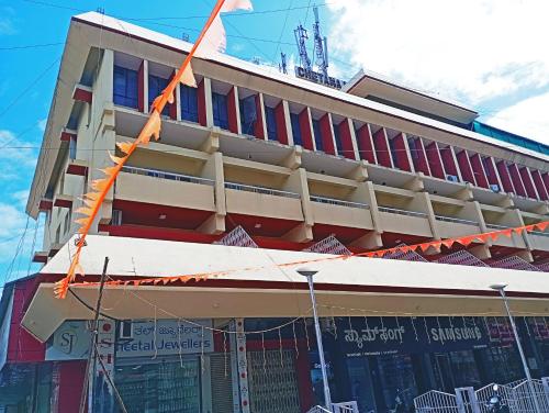 a building with an orange ribbon in front of it at Hotel Chetana in Dāvangere