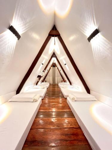 a row of white beds in a attic at Dahun Villas Siargao in General Luna