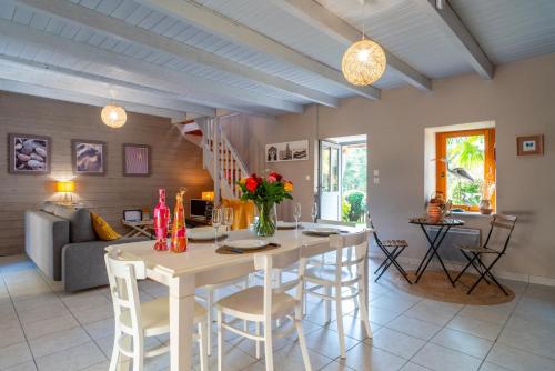 une cuisine et un salon avec une table et des chaises dans l'établissement La Libellule - Charmante maison avec jardin à Séné, à Séné